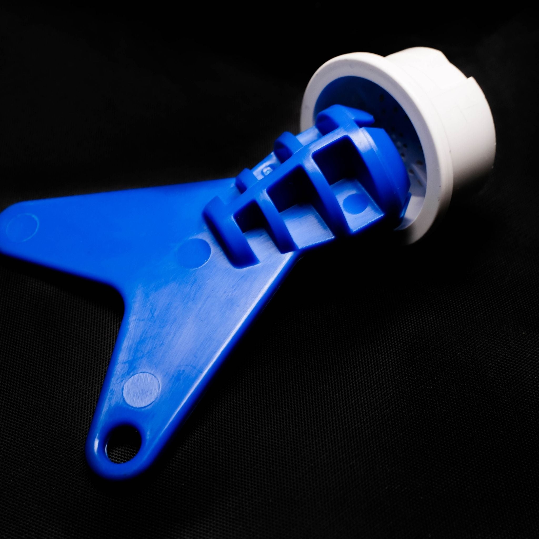 Blue plastic replacement tool with a white handle on a black background